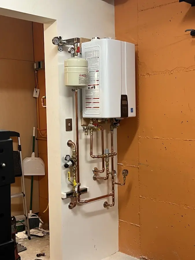Plumbing technician inspecting water heater connections in Merrimac